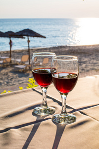 两杯红酒与日落海滩在背景上