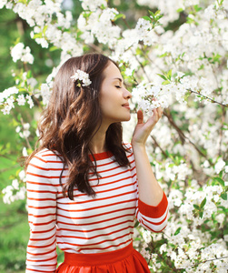 在开花春天的花园美丽的年轻女子的画像