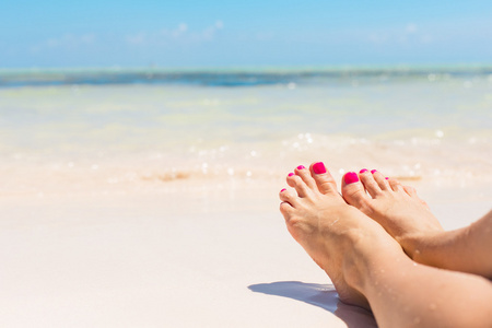 女人的赤脚在沙滩上