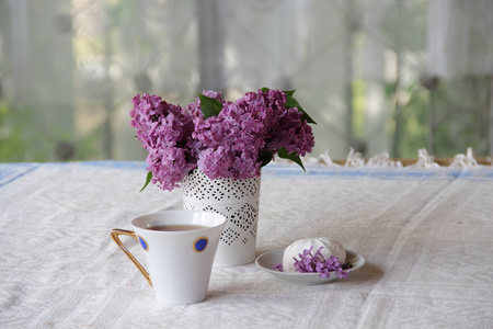 丁香花束在镂空花瓶和茶与西风