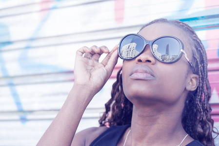 美丽的非洲年轻女子带着太阳眼镜，城市风格