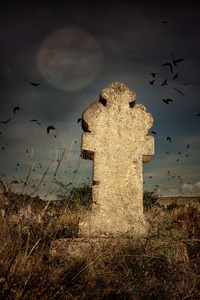 万圣节可怕的墓地里有古老的十字架,月亮和一群乌鸦照片