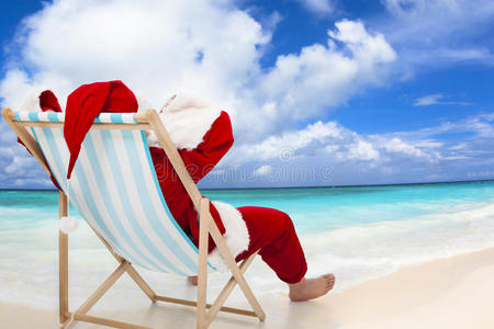 圣诞老人坐在沙滩椅上。圣诞假期概念。