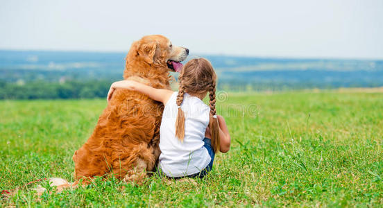 带着金毛猎犬的小女孩