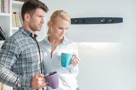 站着喝咖啡的年轻夫妇