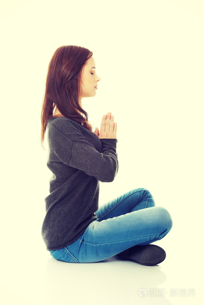 漂亮的学生女孩打坐莲花姿势