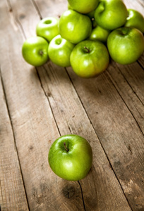 成熟的青苹果在木背景上。水果