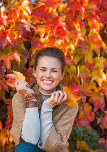 微笑的年轻女子在秋叶的肖像