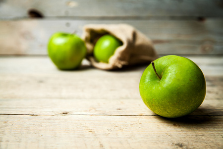 水果。成熟的绿色苹果与麻布, 在木背景