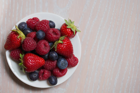 覆盆子，草莓，蓝莓在白板上