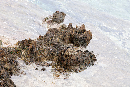 尖锐的灰色岩石，在海滩上