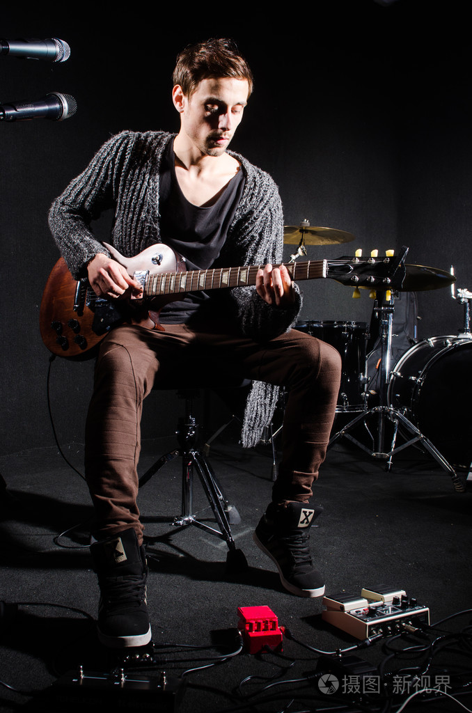 人在黑暗的房间里弹吉他