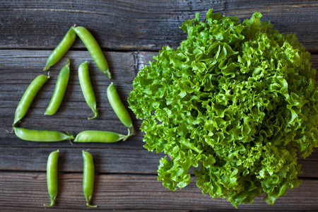 沙拉生菜和绿色豌豆健康有机营养食品对老式木制背景
