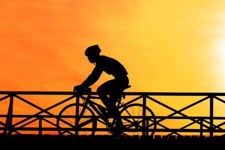 一名骑单车的日落时的剪影图片