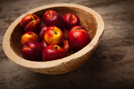 桌上的木碟里有新鲜的桃子