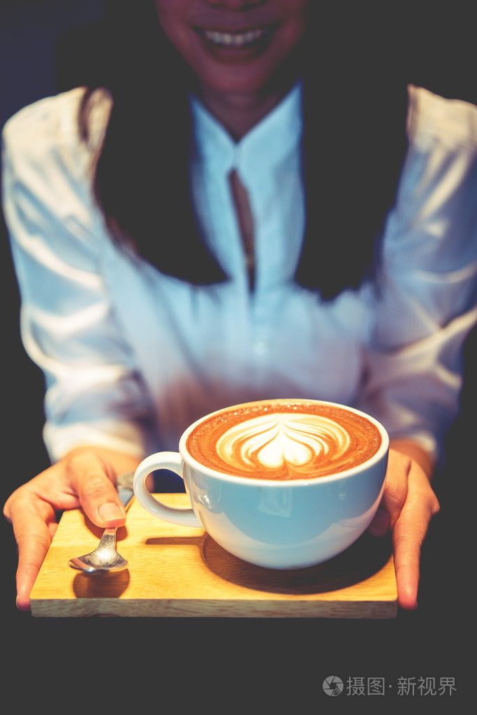 女人拿着咖啡摩卡热在木桌上