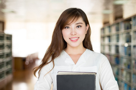 亚洲女学生举行书在图书馆