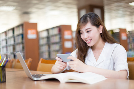 女学生在图书馆中使用手机