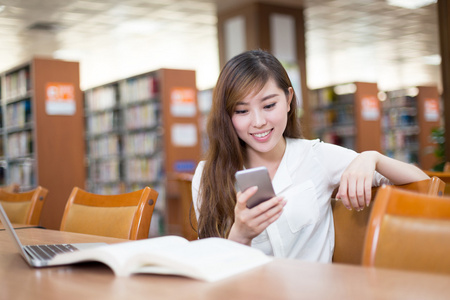 女学生在图书馆中使用手机