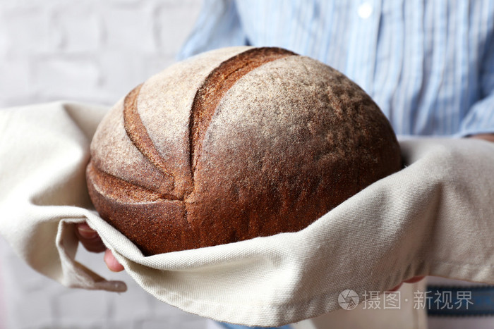 女人抱着可口的新鲜面包关闭