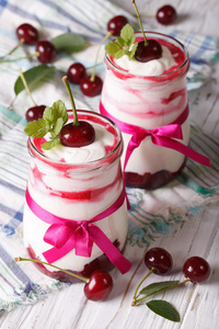 酸奶与樱桃在玻璃罐子特写在桌子上。 韦尔蒂