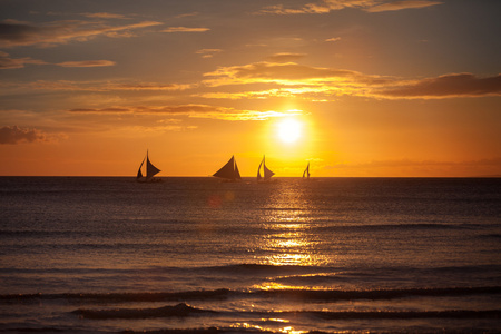 日落时在热带海洋上的帆船