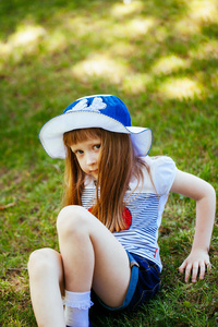 一个可爱的女孩在公园的草地上的肖像