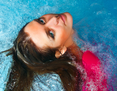 Young appy woman splashing water