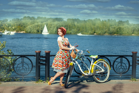 女孩站在附近一辆自行车在河边