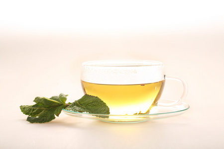 在白色背景上的透明杯薄荷绿茶