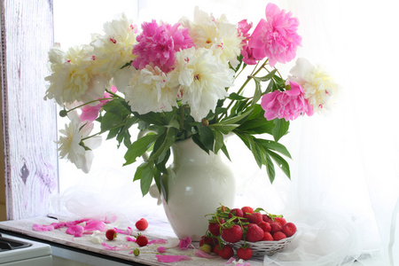 草莓在汪洋的花瓶和一束牡丹在一张白纸