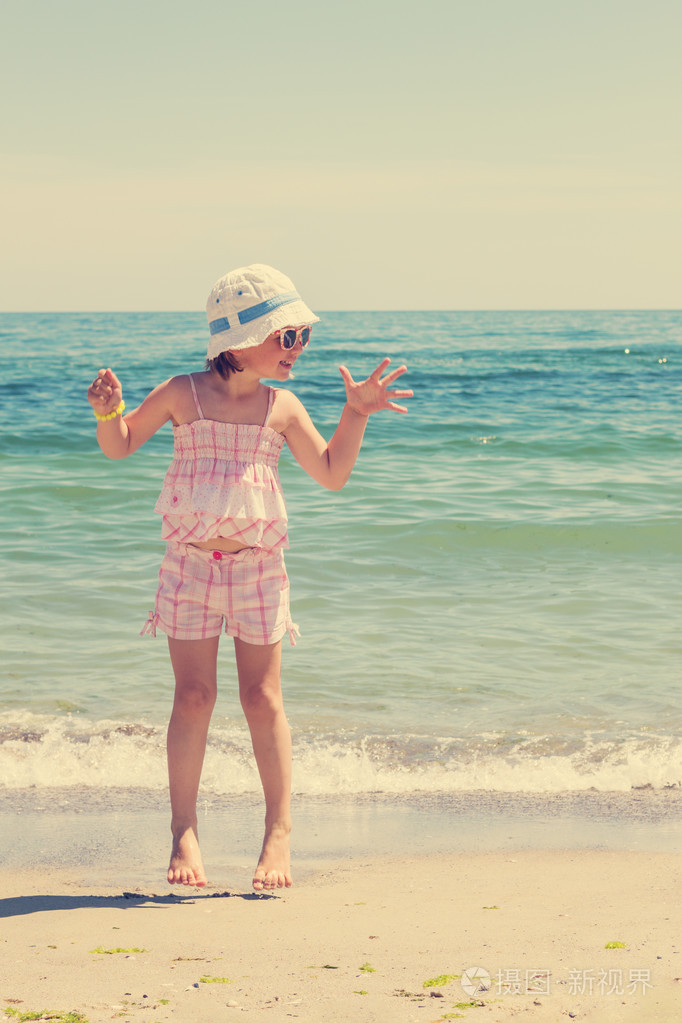 运行和沙滩上玩耍的小女孩.图像是汀苔