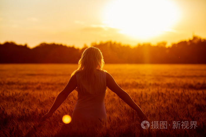 美丽浪漫的女孩在户外。美丽的少女模型女孩穿便服短对太阳的光场。吹着长长的头发。秋天。发光的太阳，阳光。背光。在温暖的颜色色调