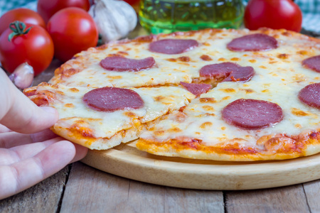 自制腊肠披萨上一块木板，准备吃