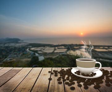 海上日出时桌上的咖啡的杯子