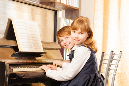 两个可爱的女孩弹钢琴