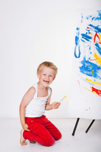 小孩子画描绘在画架上。教育。创造力。工作室画像在白色的背景