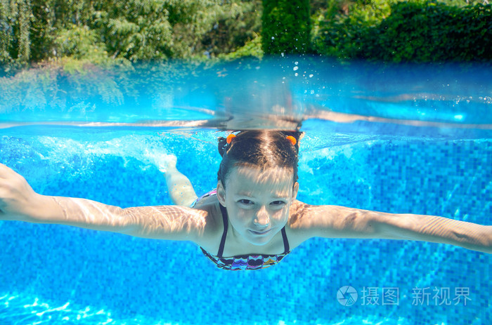 快乐儿童游泳在游泳池水下,好动的小孩游泳, 踢球和乐趣,儿童水运动