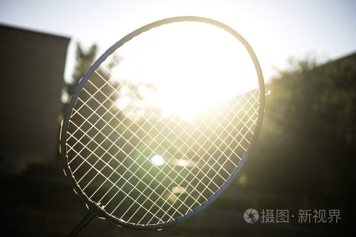 网球羽毛球拍的太阳强光的照射下绽放筛选的背景