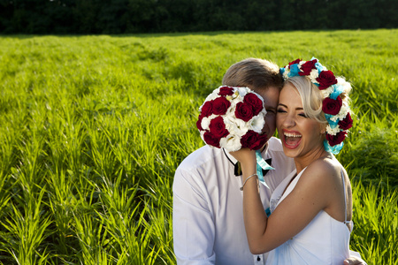 幸福的新娘和新郎在明亮的绿色的田野