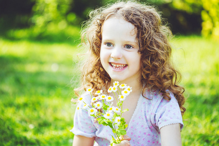 母亲一天雏菊小女孩微笑着,用一束白色的雏菊.母亲一天概念照片