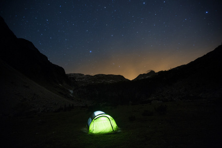 帐篷矗立在星空下的山地牧场上图片