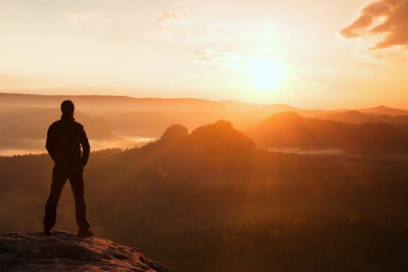 徒步旅行者站在砂岩岩岩帝国公园和注视着朦胧有雾的早晨谷到太阳美丽时刻的自然奇迹的尖角