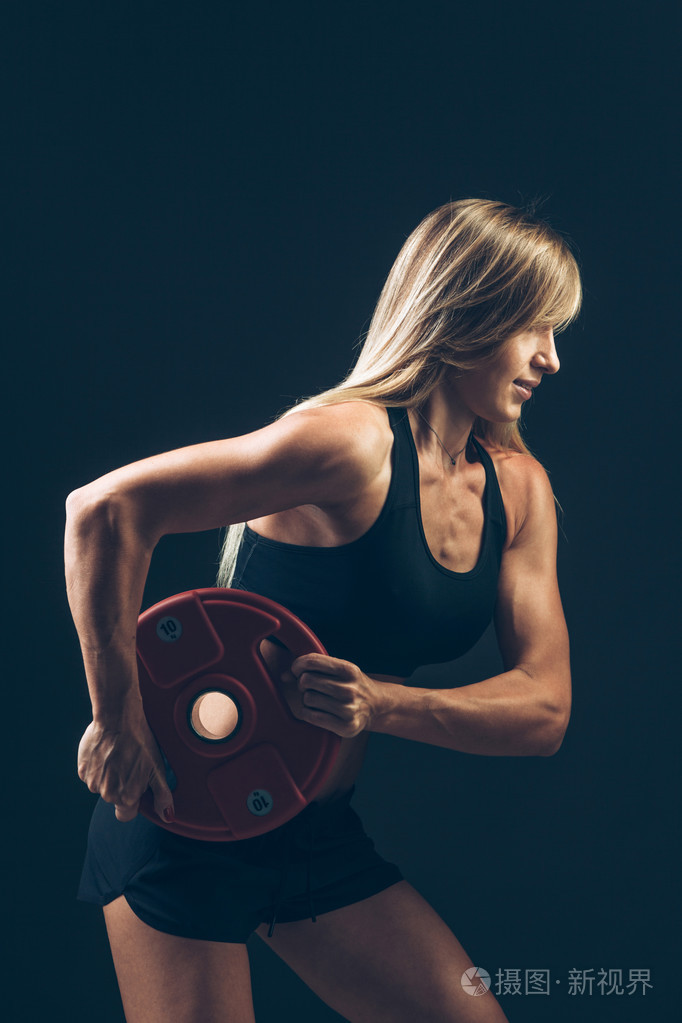 健身女人做重量训练,通过提升重物杠铃,体育生活方式