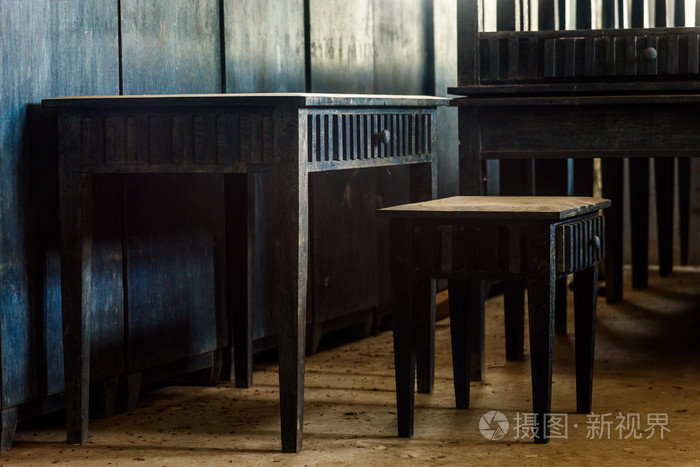 在一个漆黑的房间从th光照射的老木书桌