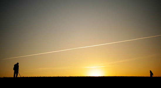 一位摄影师在日落期间的侧面影像
