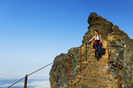 年轻的女子在蜿蜒山徒步路径在 Pico 做 Arieiro