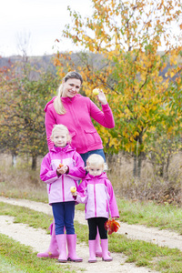母亲和女儿在秋季自然与苹果