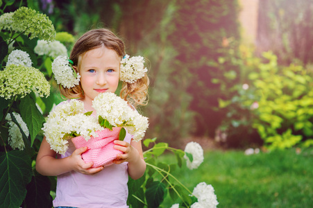 可爱的快乐儿童女孩玩绣球花粉红色针织篮在夏天花园附近开花布什在