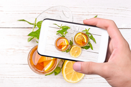 手中的智能手机的照片冰柠檬茶
